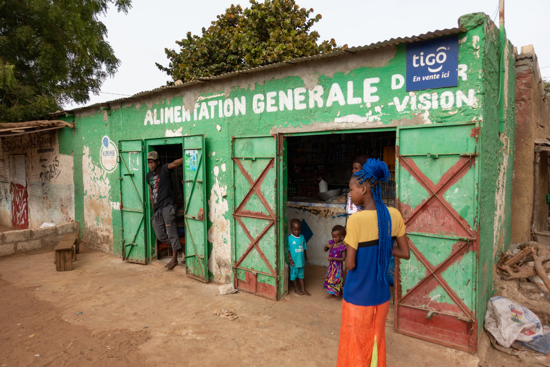 Familie vor einem grünen Lebensmittelgeschäft im Senegal