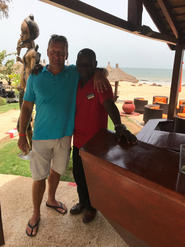Birk Möbius mit einem Mitarbeiter an der Bar seiner Unterkunft im Senegal