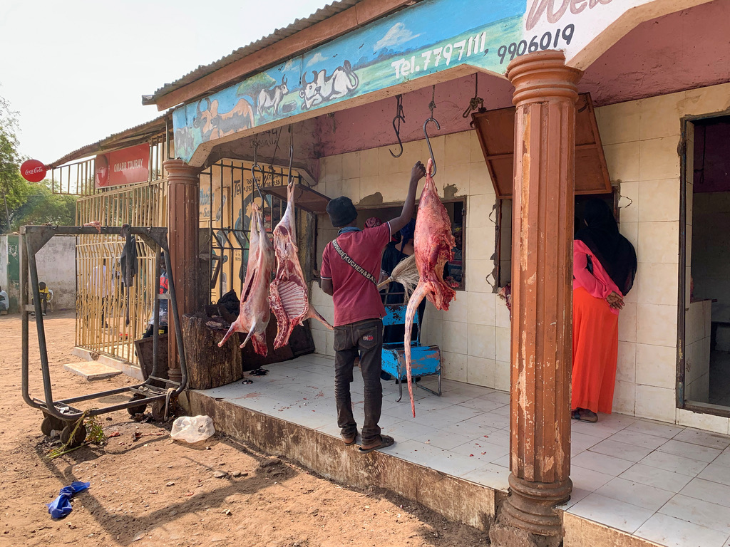 Metzgerei mit aufgehängtem Fleisch an einer Straße