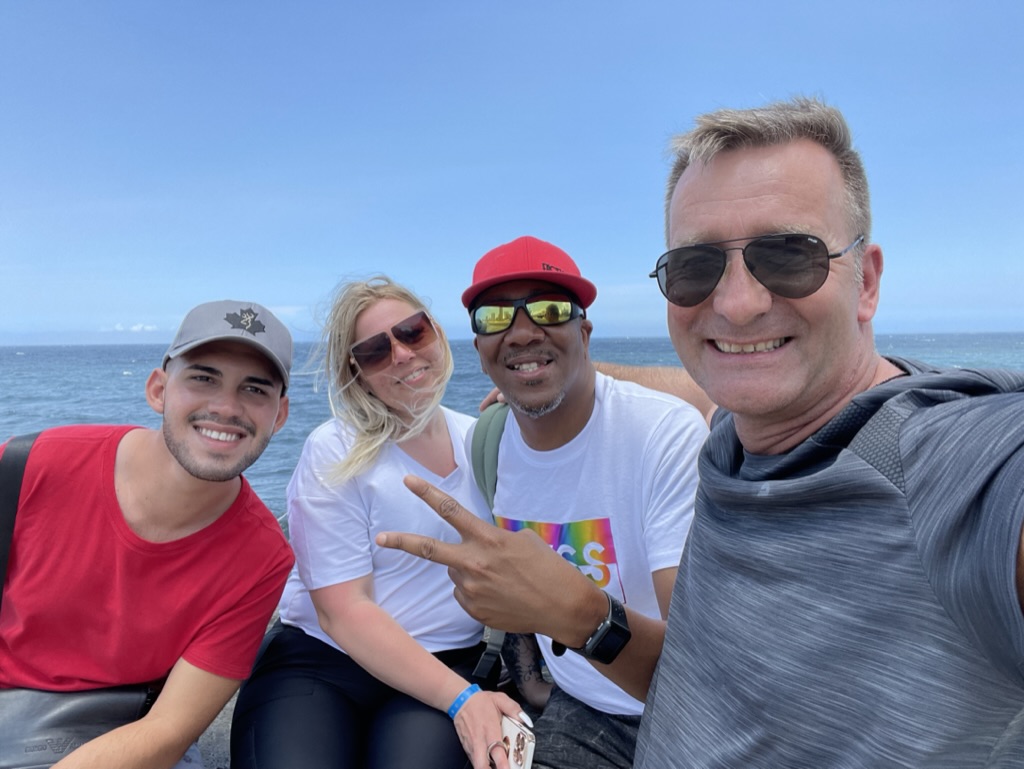 Birk Möbius und Reisebegleiter lächeln für ein gemeinsames Foto am Meer auf Kuba