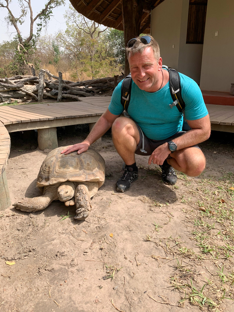 Birk Möbius kniet neben einer großen Schildkröte