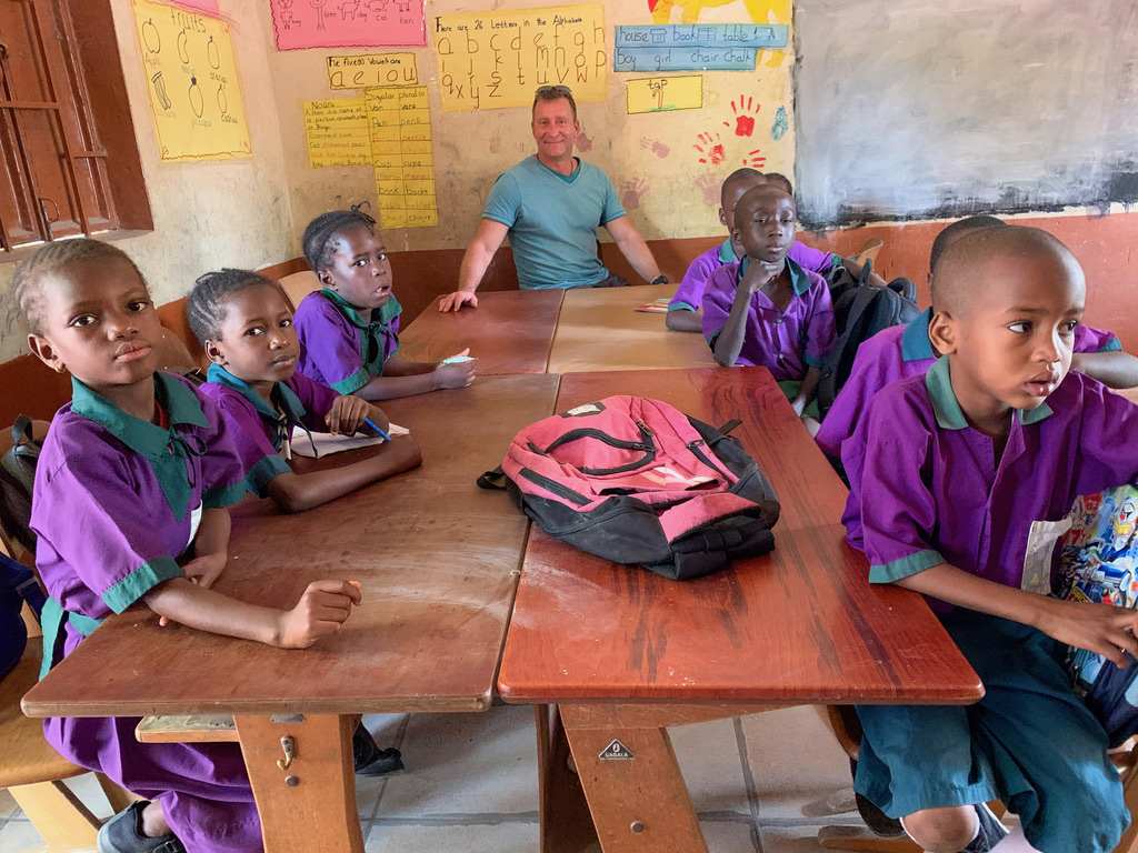 Birk Möbius mit Kindern in einem Klassenzimmer mit Lernplakaten