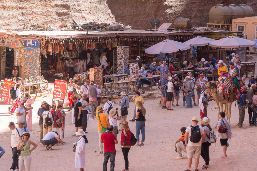 Besucher, Stände und Kamele auf einem Platz in Petra