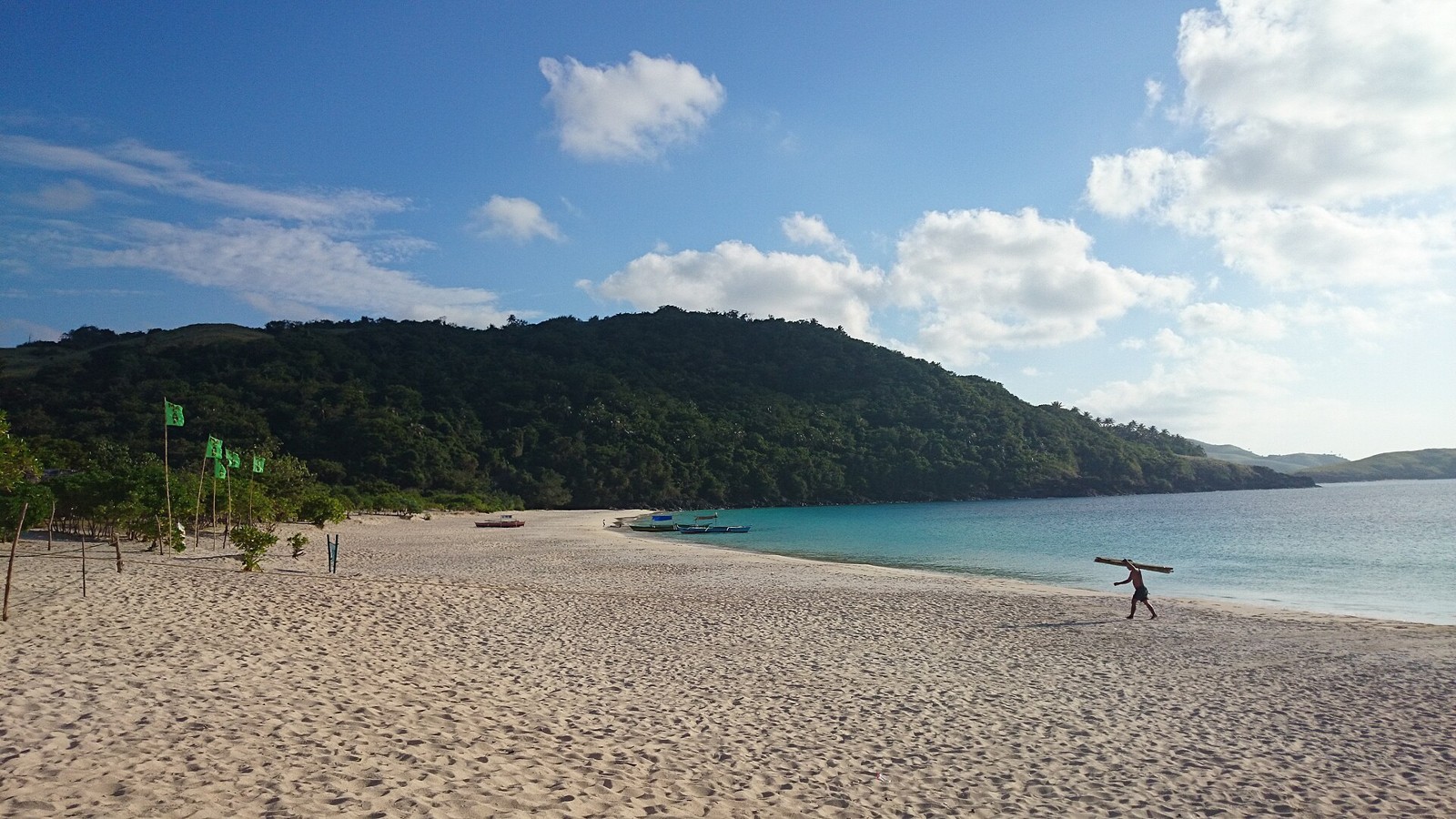 Heller Strand und grüne Hügel auf Calaguas