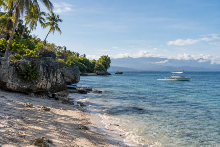 Küste auf Cebu mit tropischer Vegetation und Auslegerboot